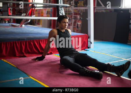 Female boxer resting in gym Stock Photo