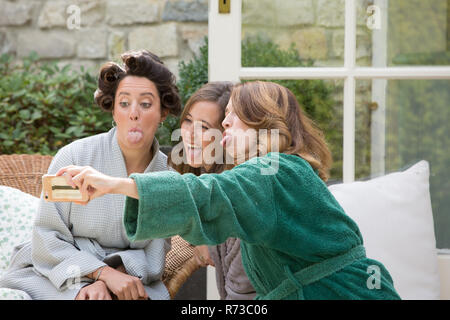 Bride and friends taking selfie on morning of wedding day Stock Photo