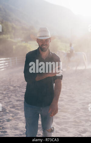 Cowboy in sunlit equestrian arena, portrait, Primaluna, Trentino-Alto Adige, Italy Stock Photo