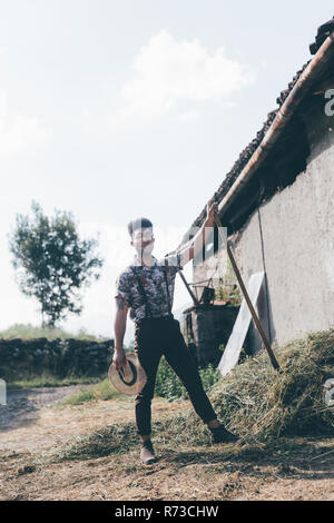 Full length portrait of a male agricultural worker holding a shovel ...