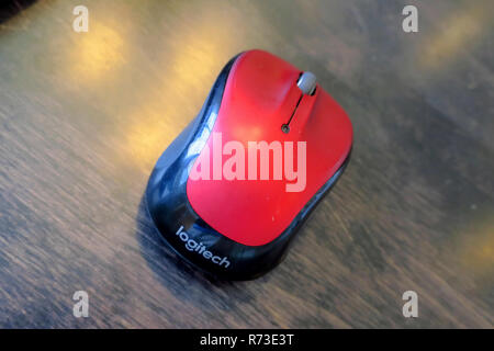 A red wireless mouse on a wood table. Stock Photo