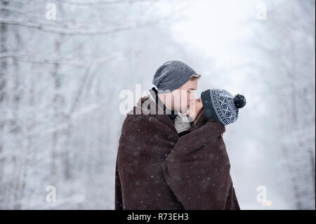A couple is kissing in the snowy forest Stock Photo - Alamy