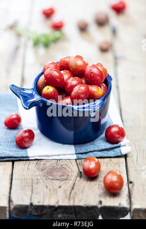 Baby plum tomatoes in blue bowl, still life Stock Photo