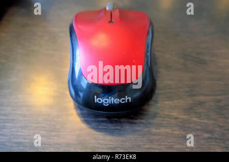 A red wireless mouse on a wood table. Stock Photo