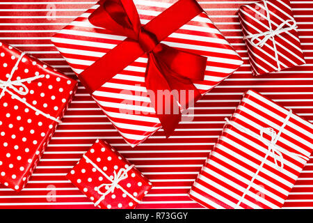 Various size wrapped in red paper with ornament Christmas gift boxes on red with white lines background Stock Photo