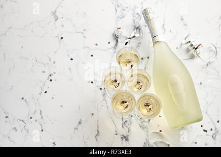Champagne glasses and bottle placed on white marble background Stock Photo