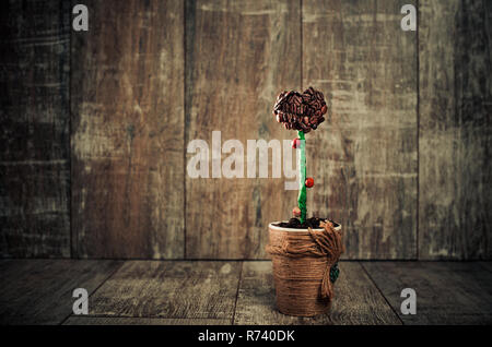 elegant pot with coffee beans flower at vintage wooden background Stock Photo