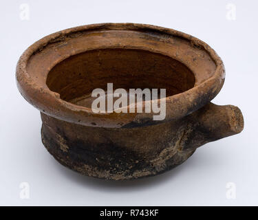 Pottery saucepan on three legs, with lid edge and stem as handle, saucepan pan holder kitchenware earth discovery ceramic earthenware glaze lead glaze, hand turned molded glazed baked Pottery saucepan on three legs Lightly curled bottom. Red shard and internally glazed. Cylindrical in shape with outstanding top edge. Lid edge Angled handle as handle. Many traces of use: soot on the bottom cracks and scratches in the glaze on the inside archeology indigenous pottery food preparation cooking kitchen Stock Photo