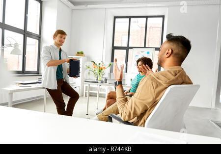man showing tablet pc to creative team at office Stock Photo