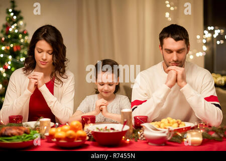 family praying before meal at christmas dinner Stock Photo