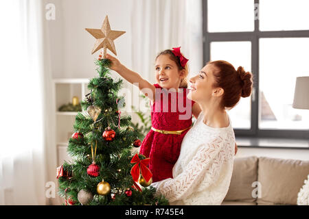 mother and daughter decorating christmas tree Stock Photo