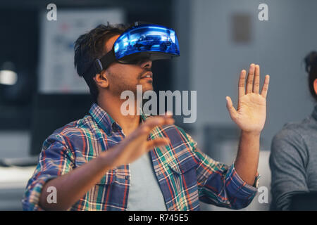 man in virtual reality headset at night office Stock Photo