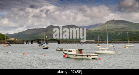 Barmouth, Wales, UK - May 11, 2011: A passenger train crosses the Mawddach Estuary on the Barmouth Bridge under Cadair Idris and other mountains of Sn Stock Photo