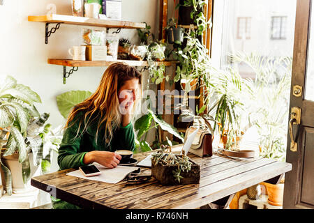 Young woman using laptop in cafe Stock Photo