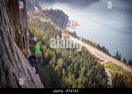 Young female rock climber climbing rock face, elevated view, The Chief, Squamish, British Columbia, Canada Stock Photo