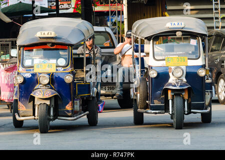 Two tuk-tuk drivers waiting for passengers with their tuk-tuks parked in front of them, Chiang Mai, Thailand Stock Photo