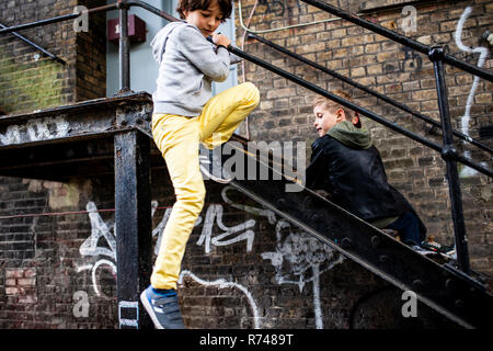 Boys playing on metal staircase Stock Photo