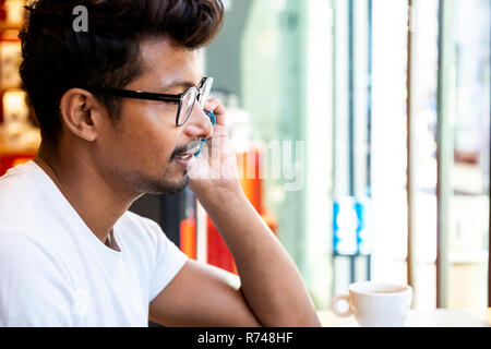 Man using smartphone in cafe Stock Photo