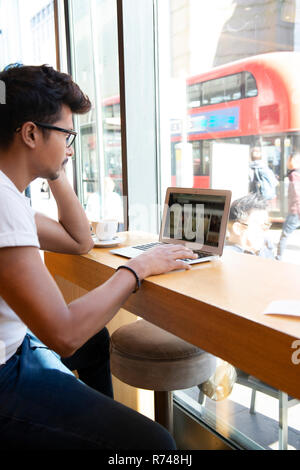 Man using laptop in cafe Stock Photo