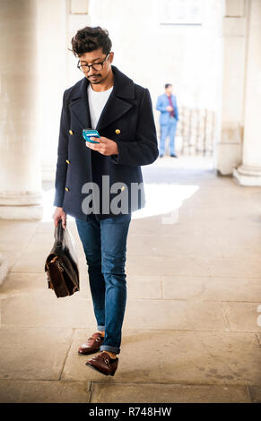 Businessman using smartphone in city Stock Photo