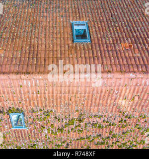 Inspection of the red tiled roof of a single-family house, inspection of the condition of the tiles on the roof of a detached house.