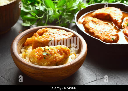 Bowl with fish curry on black stone table. Indian style food. Stock Photo