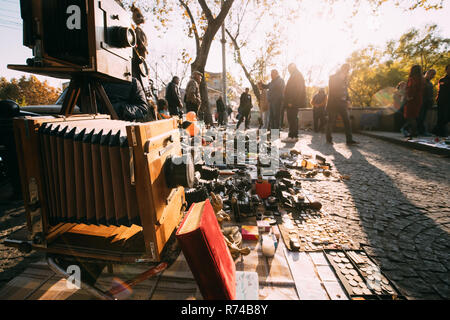 Tbilisi, Georgia. Shop Flea Market Of Antiques Old Retro Vintage Things On Dry Bridge In Tbilisi. Vintage Old Retro Large Format Camera On Ground. Stock Photo