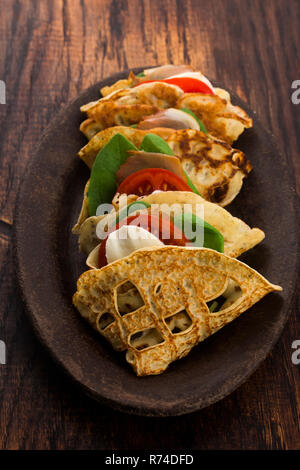 Pancakes sutffed with ham, cheese, tomatoes and spinach Stock Photo