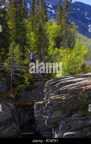 girl standing on suspension bridge. Canyon View at tre world famous waterfall Rjukandefossen, Norway Stock Photo