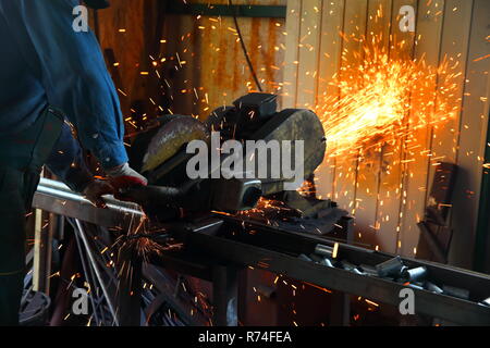 Cutting steel with a stationary large grinder. Stock Photo