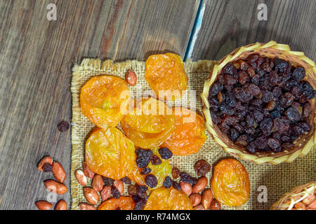 peeled raw peanuts dried apricots raisins on a wooden table background close-up Stock Photo