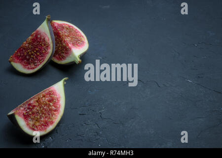 Fresh figs cut into slices. fig closeup on black concrete. place for text. diet fruit.fesh Stock Photo