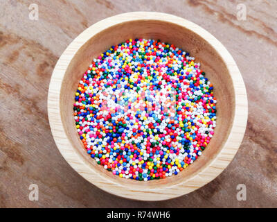 Sprinkle colorful / sugar confectionery  colored balls in wooden bowl - for sprinkle cake or Ice cream decorative Stock Photo