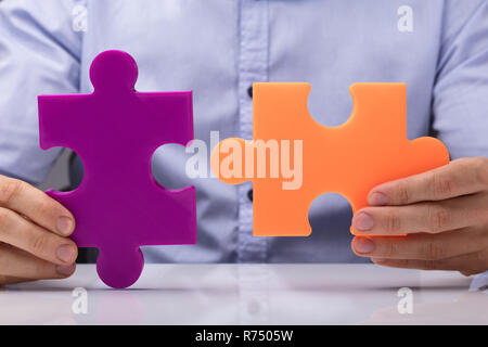 Person Holding Two Jigsaw Puzzle Stock Photo