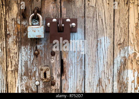 two locks on old vintage wooden garage door, peeling paint Stock Photo
