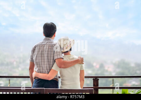 Rear view of a happy asian middle aged a couple on bench Stock Photo