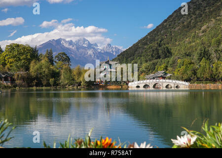 Jade Dragon Snow Mountain and the Suocui Bridge over the Black Dragon Pool in the Jade Spring Park, Lijiang, Yunnan province, China. Stock Photo