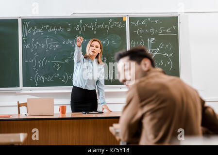 Selective focus of teacher showing something to student Stock Photo