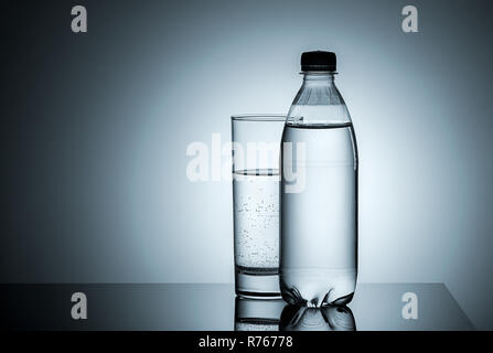 Plastic bottle and glass with water Stock Photo