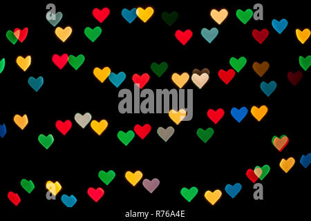 Heart shaped qustom bokeh created from decoration lights and isolated on black background. Stock Photo