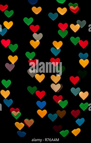 Heart shaped qustom bokeh created from decoration lights and isolated on black background. Stock Photo
