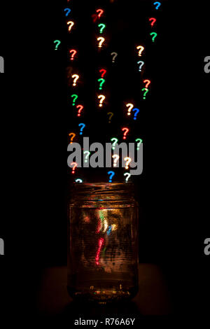 Question marks with different colors coming out of a jar. Isolated on black. Stock Photo
