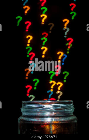 Question marks with different colors coming out of a jar. Isolated on black. Stock Photo