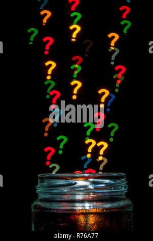 Question marks with different colors coming out of a jar. Isolated on black. Stock Photo