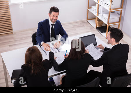 Businesspeople Having Conversation In Office Stock Photo