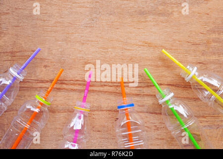 Plastic waste, Plastic bottles with straws on wooden background. Stock Photo