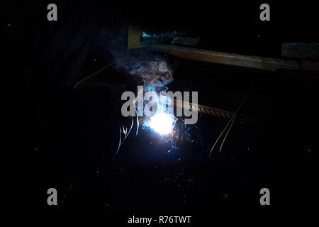 Welding of steel reinforcement. Sparks and light from welding. Electric welding Stock Photo