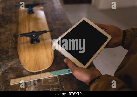 Man using digital tablet in workshop Stock Photo