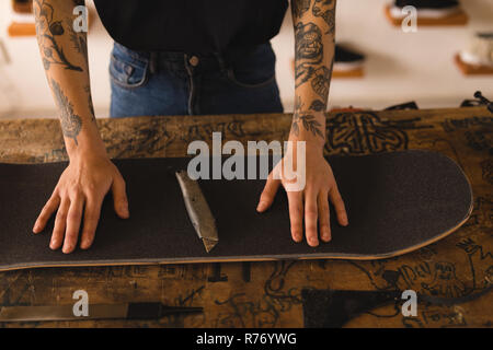 Woman repairing skateboard in workshop Stock Photo