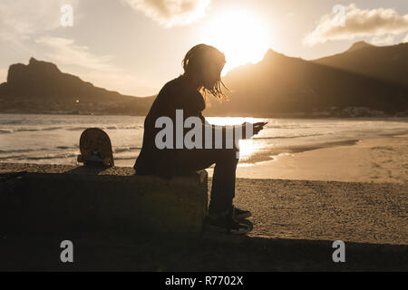 Man using mobile phone on the beach Stock Photo